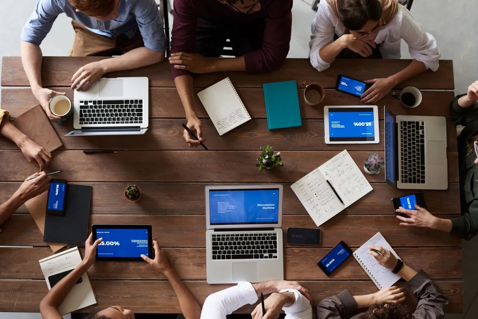 The team working together around a table of laptops and growth dashboards